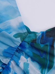 Close-up detail of blue and white abstract print on stretch mesh fabric with pleated seams