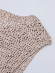 Dettaglio dell'abito beige in maglia a uncinetto con trama traforata e cuciture