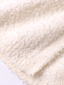 Close-up of soft cream white knit texture on this hooded winter coat for women