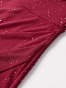 Detailed macro view of burgundy knit fabric with silver sequins and draped pleated texture