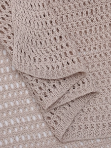 Vista macro dettagliata del tessuto a maglia beige traforato con trama a rete intricata