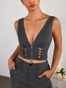 Detail eines grauen Strick-Crop-Tops mit Reißverschluss und seitlicher Schnürung