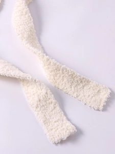 Detail of white plush knit tie with soft chenille texture and fuzzy fiber material
