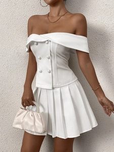 Close-up of white off-shoulder slim-fit top featuring double-breasted buttons and lapels