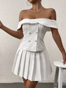 Detail view of white off-the-shoulder top with double-breasted buttons and pleats