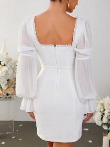 Détail de robe blanche dos nu à encolure carrée avec volants et manches bouffantes
