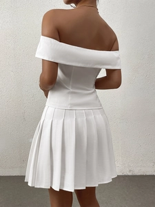 Detail view of the back showing slim fit off-shoulder white top and pleated skirt