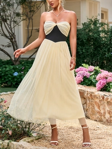 Detalle de vestido de tul elegante con pliegues beige y corsé negro en la cintura