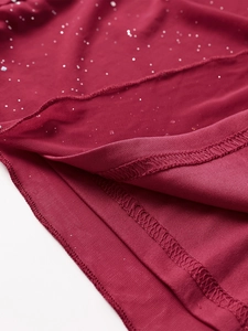 Close-up of wine red mesh fabric with silver sequins and fine stitching details