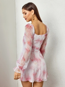 Détails de la robe fleurie rose clair avec manches longues transparentes et col carré