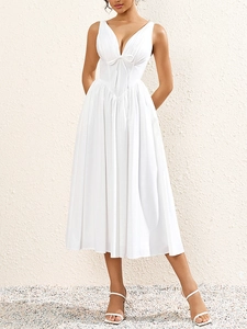 Détail de robe midi blanche avec décolleté en V profond, bustier à nœud et texture plissée