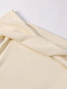 Macro detail of creamy white knitted fabric texture showing honeycomb stitch pattern