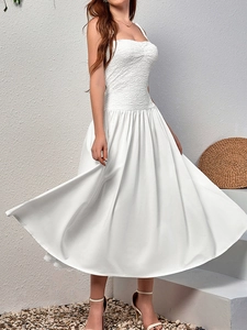 Detailed close-up of smocked bodice and flowing white lace strap maxi dress
