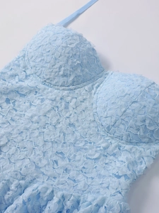 Detail of light blue lace dress with 3D floral petals and halter neck strap close-up