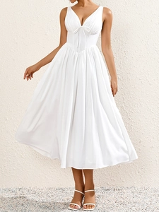 Détail de la robe blanche à col en V avec encolure plissée et élégant nœud papillon noué