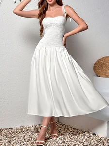 Detail of white maxi dress featuring elastic smocked bodice and bow shoulder straps