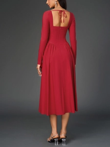 Détail d'une robe trapèze rouge dos nu avec des lacets élégants et un col carré chic
