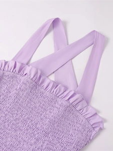 Detailed view of the lavender smocked texture and cross-strap design of this dress