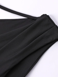 Dettaglio del tessuto in maglia nera con spalline sottili e finiture arricciate