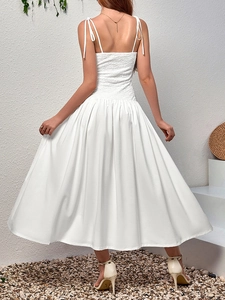 Detail of white lace-up straps and pleated texture on the back of a maxi dress