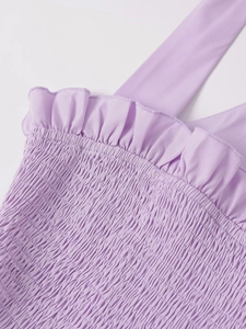 Macro shot of smocked lavender fabric with ruffled edges and thin shoulder straps