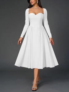 Détail du décolleté en cœur et des plis structurés sur la robe midi blanche à manches longues