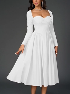 Détail du décolleté en cœur et du bustier cintré sur une robe mi-longue évasée blanche