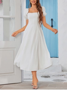 Detail of white midi dress with square neckline and vintage puff sleeves in a resort setting