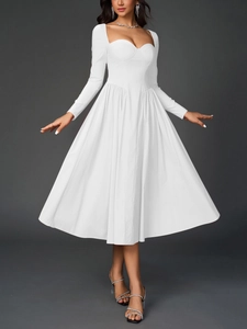 Détail d'une robe mi-longue blanche à manches longues avec décolleté bustier et jupe plissée