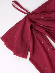 Détail macro du tissu en maille bordeaux avec sequins argentés étincelants et plis fins