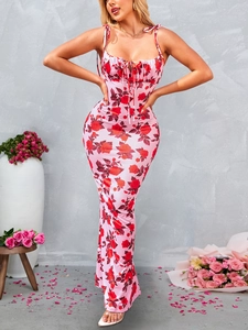 Détail de robe longue rose à imprimé roses avec bretelles et devant froncé lacé