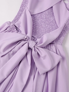 Detail of lilac dress featuring smocked elastic back and a large decorative bow