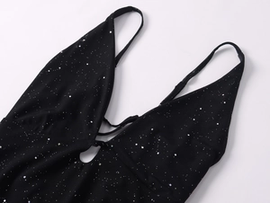Détail d'une robe noire à paillettes avec reflets argentés et fines bretelles