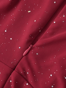 Détail du tissu en maille rouge avec paillettes argentées et fermeture éclair invisible