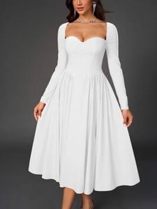 Détail d'une robe blanche à manches longues avec décolleté en cœur et plis