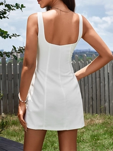 Detail of white mini dress featuring waffle knit texture and open back U-neck design