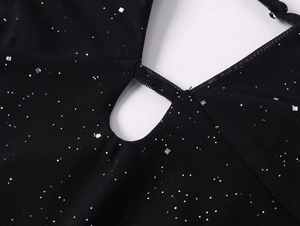 Gros plan sur tissu en maille noire avec paillettes argentées et détails ajourés au décolleté