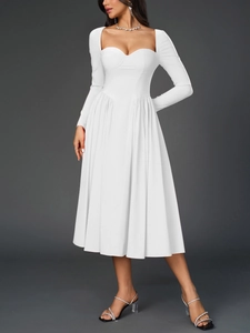 Détail du décolleté en cœur et des plis sur la robe mi-longue blanche à manches longues