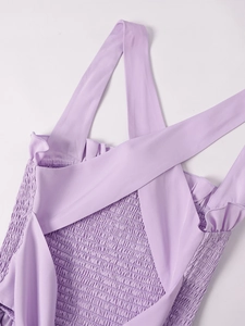 Detail of lavender smocked back design with cross straps and ruffle trim on the dress