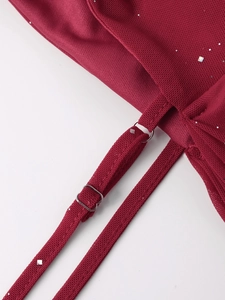 Détail de la robe en maille rouge à paillettes argentées avec bretelle réglable en métal