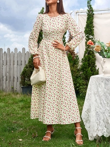 Détail de l'imprimé floral rouge sur robe maxi crème à manches longues en mousseline