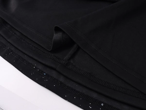 Détail de l'ourlet de la robe en tulle noir avec paillettes argentées et double surpiqûre