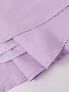 Detail of light purple dress fabric with layered ruffles and precise single-line stitching