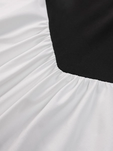 Detailed close-up showing black and white contrast stitching with pleated fabric texture