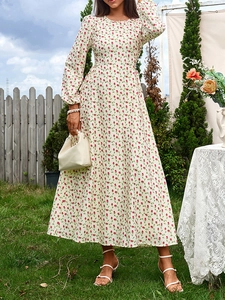 Détail de la robe à manches longues avec roses rouges sur tissu blanc cassé