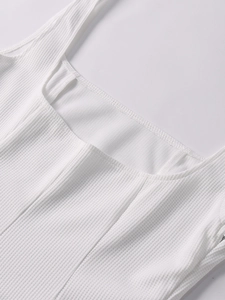 Detail view of white ribbed knit fabric with square neck design and fine stitching