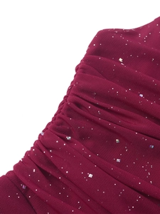 Detail of red ruched mesh dress with shimmering sequins and pleated fabric texture