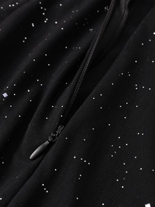 Macro detail of black mesh fabric with silver sequins and hidden zipper closure