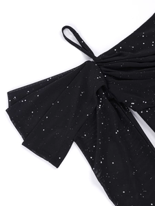 Détail d'une robe en tulle noir avec sequins argentés, grand nœud et fines bretelles