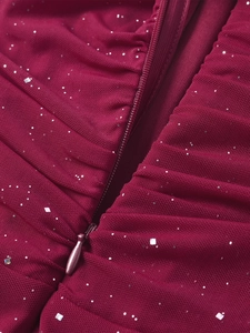 Macro detail of wine red sequin dress showing invisible zipper and pleated mesh fabric
